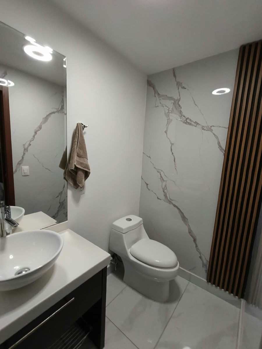 Baño principal con muro de mármol y lavabo de cerámica