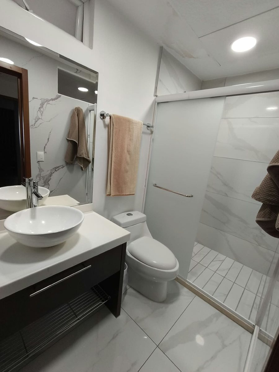 Baño con cancel de cristal y lavabo de cerámica