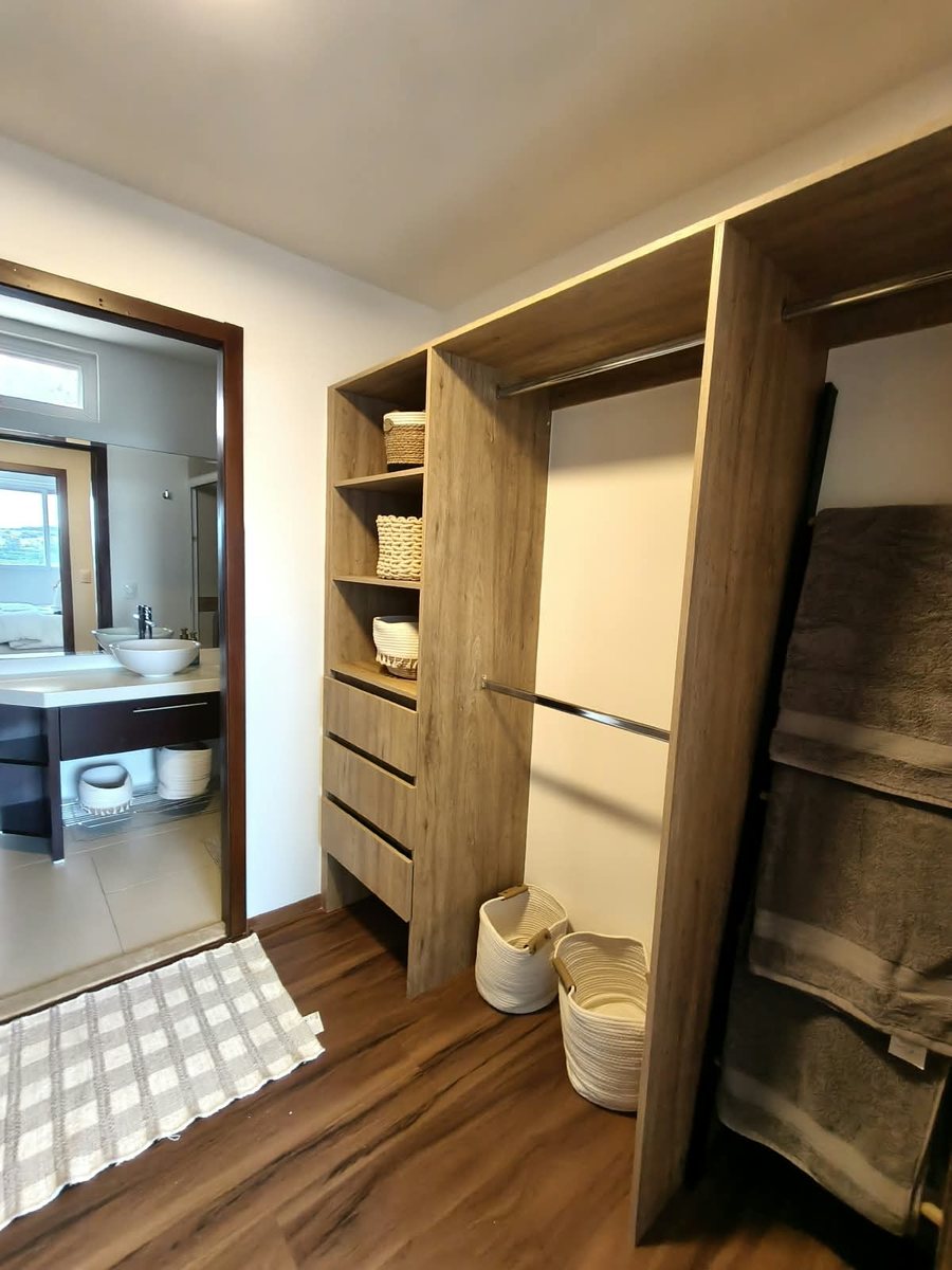 Vestidor de madera con acceso al baño de la recámara principal