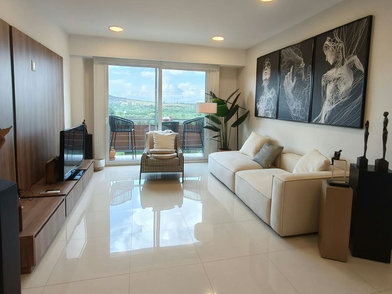 Sala del departamento con ventanal hacia el balcón
