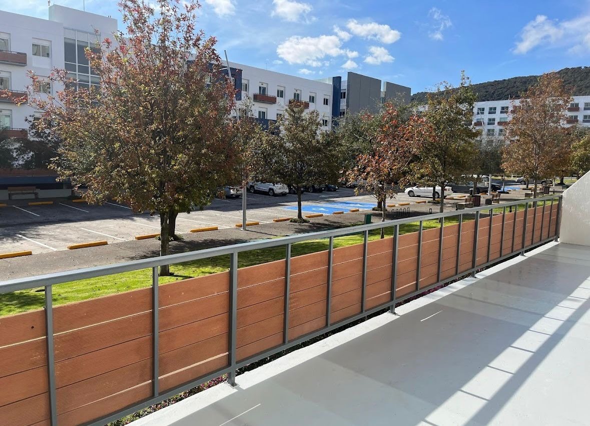 Terraza privada con barandal de madera y vista a los jardines