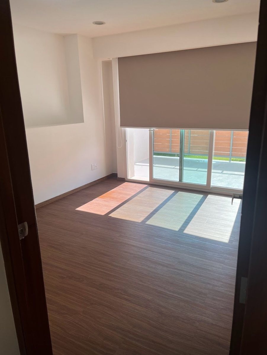 Recámara con piso de madera y salida a la terraza