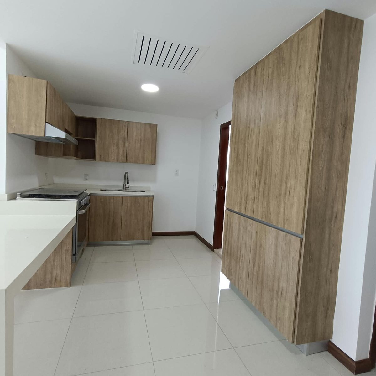 Cocina integral con alacenas de madera, estufa y tarja