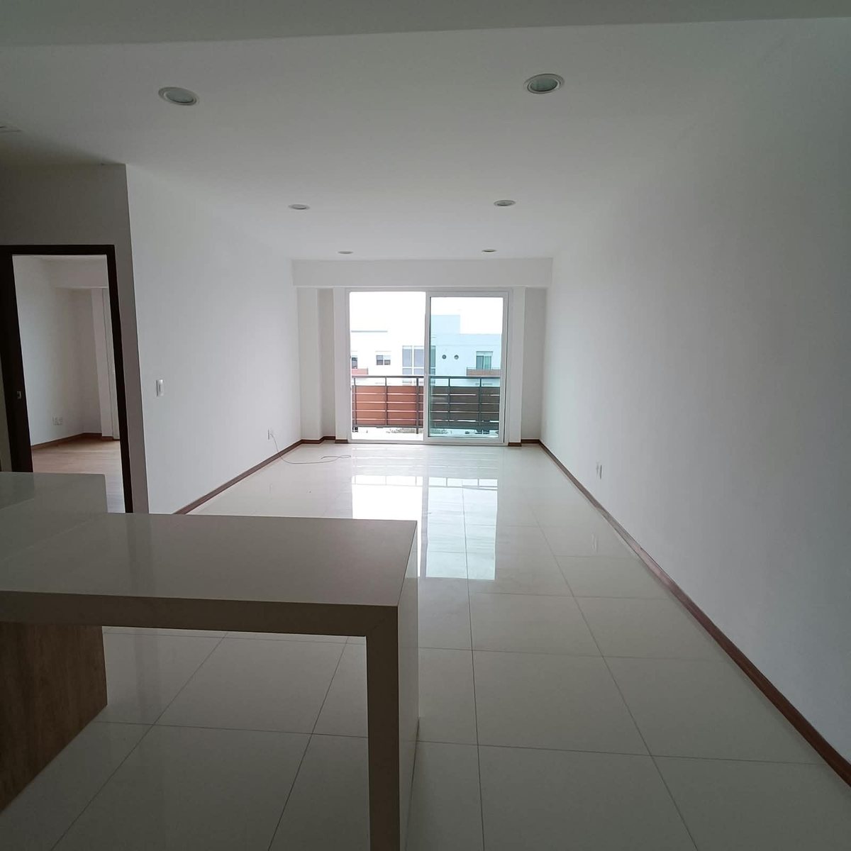 Sala y comedor con barra y ventanal hacia el balcón