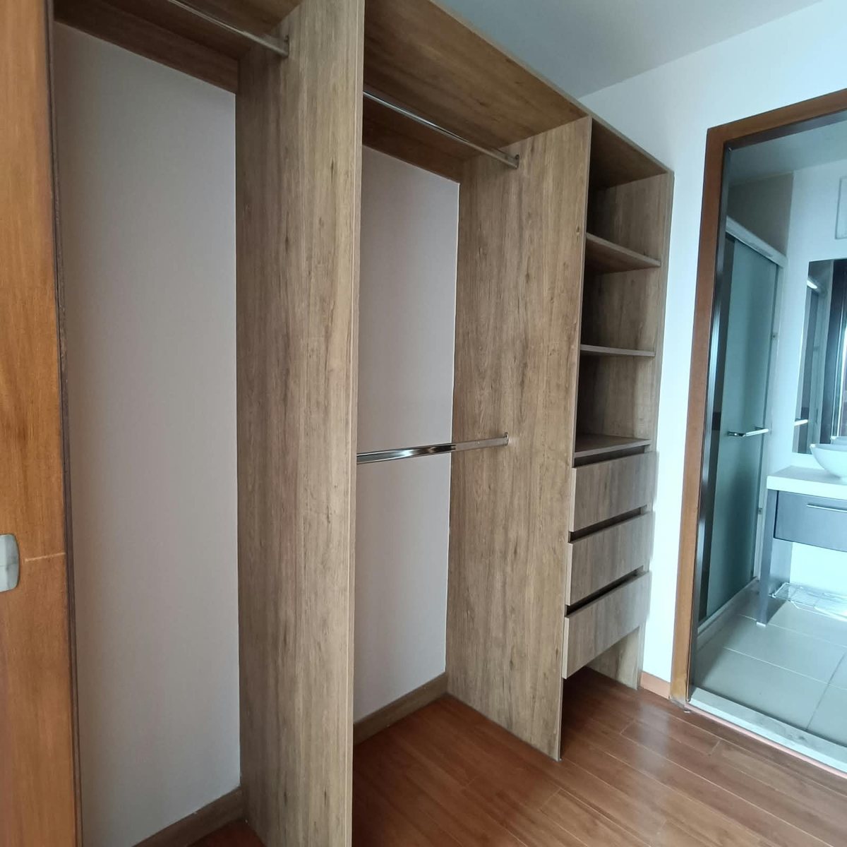 Walk-in closet de madera con acceso al baño