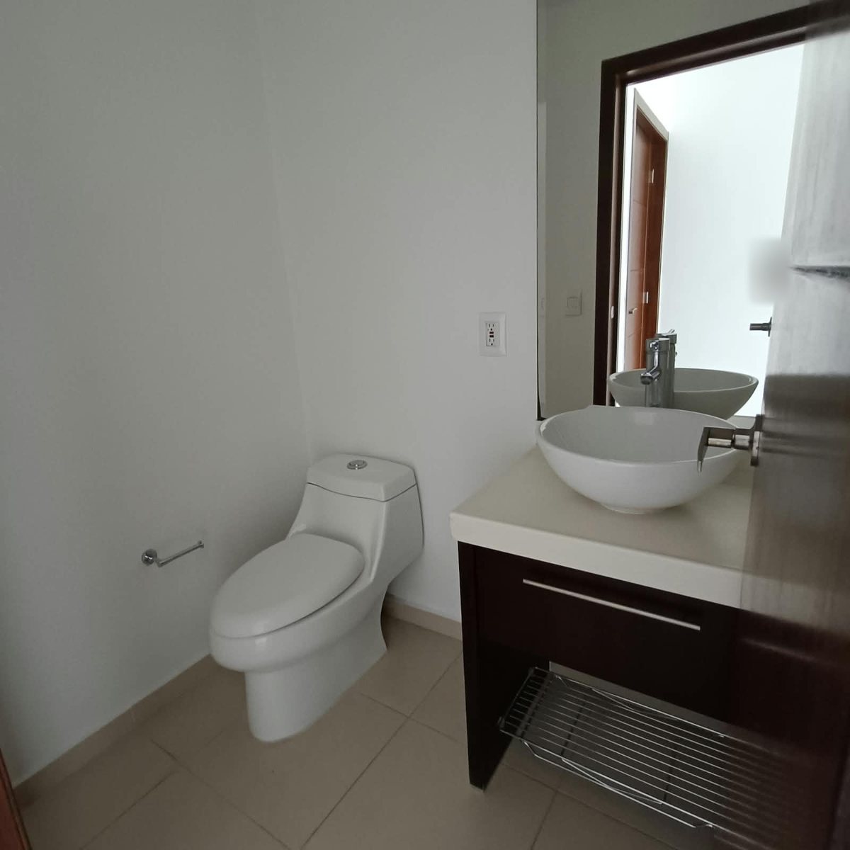 Baño con lavabo de cerámica y mueble de madera