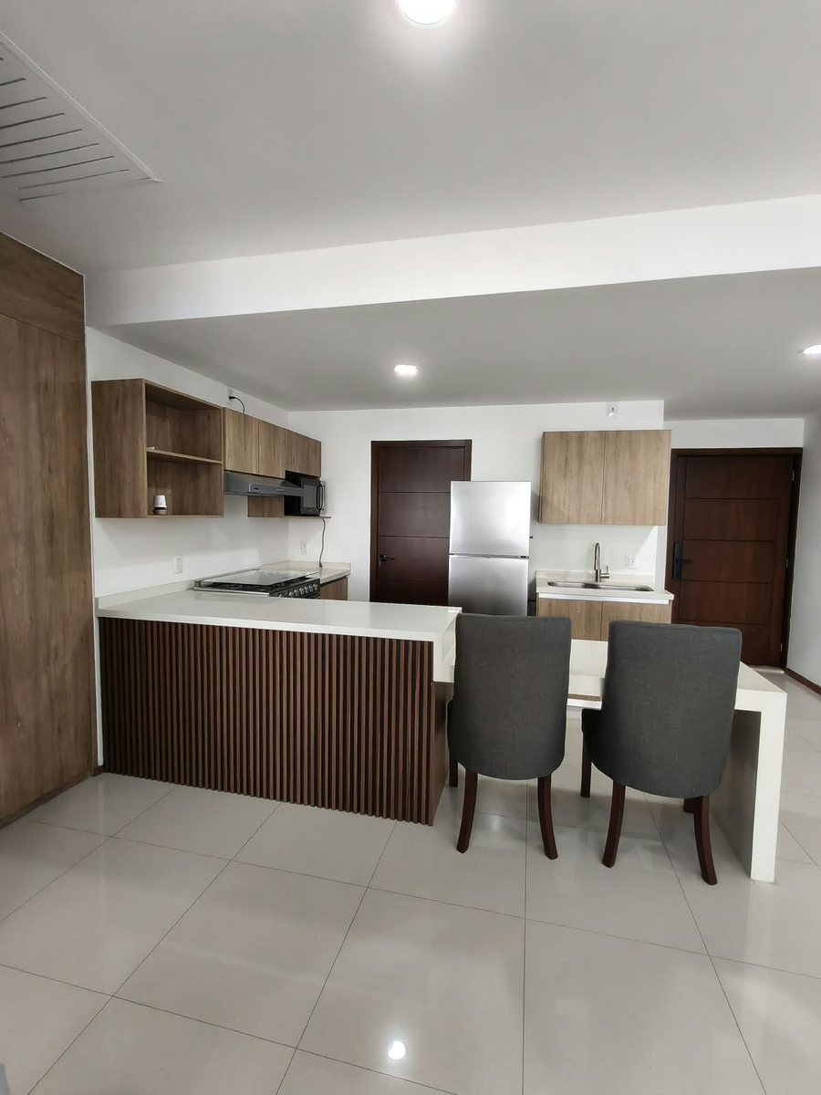 Comedor con barra y cocina integral equipada