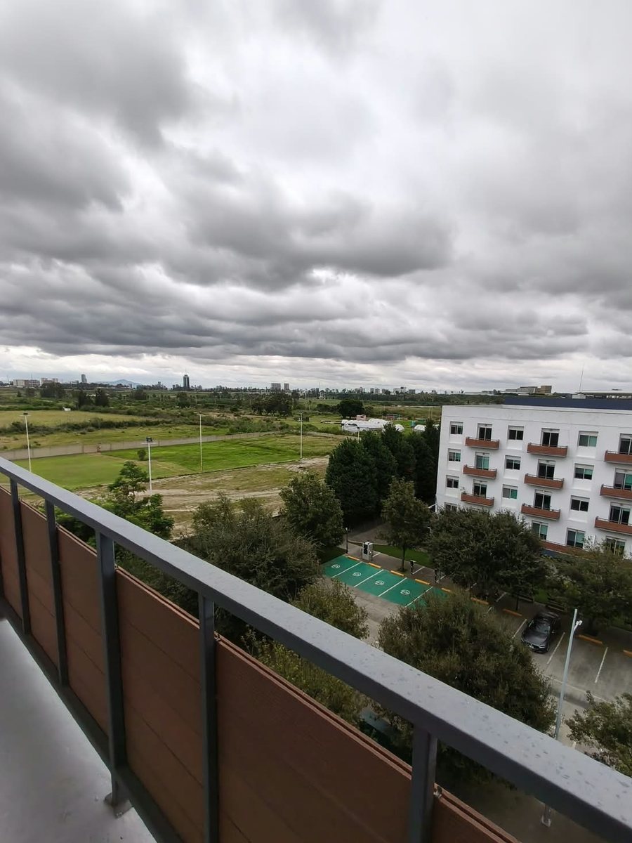 Vista desde el balcón hacia los jardines y el estacionamiento