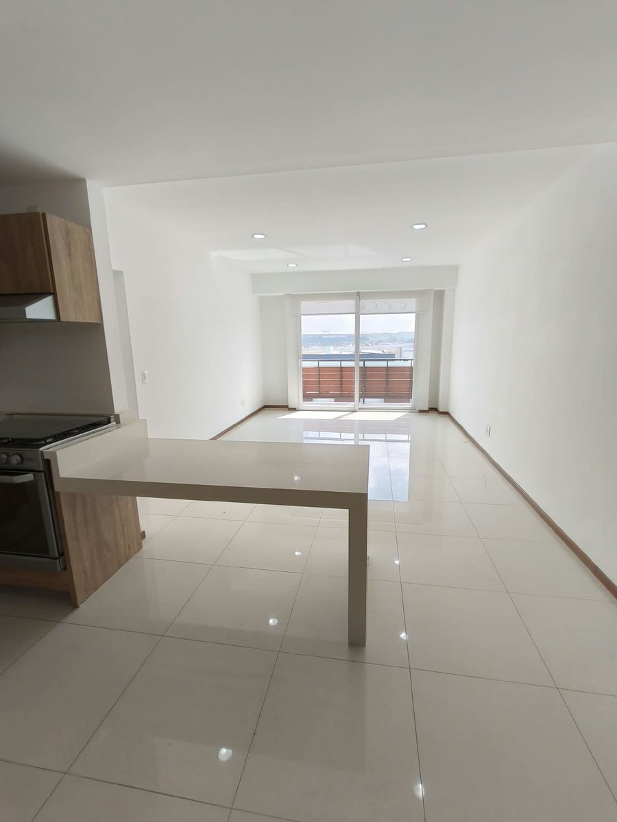 Sala y comedor con barra y ventanal hacia el balcón