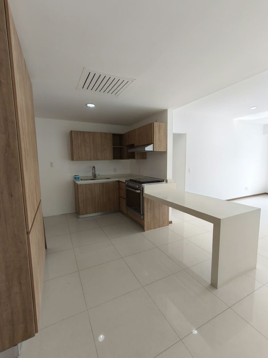 Cocina integral con barra, estufa y alacenas de madera