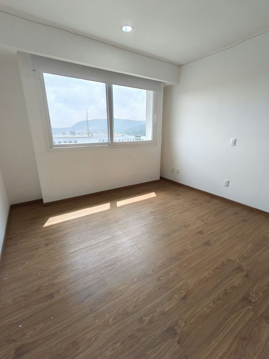Recámara principal con ventana y piso de madera