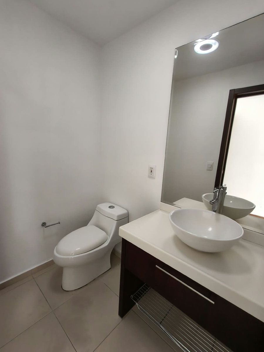 Baño con lavabo de cerámica y espejo grande