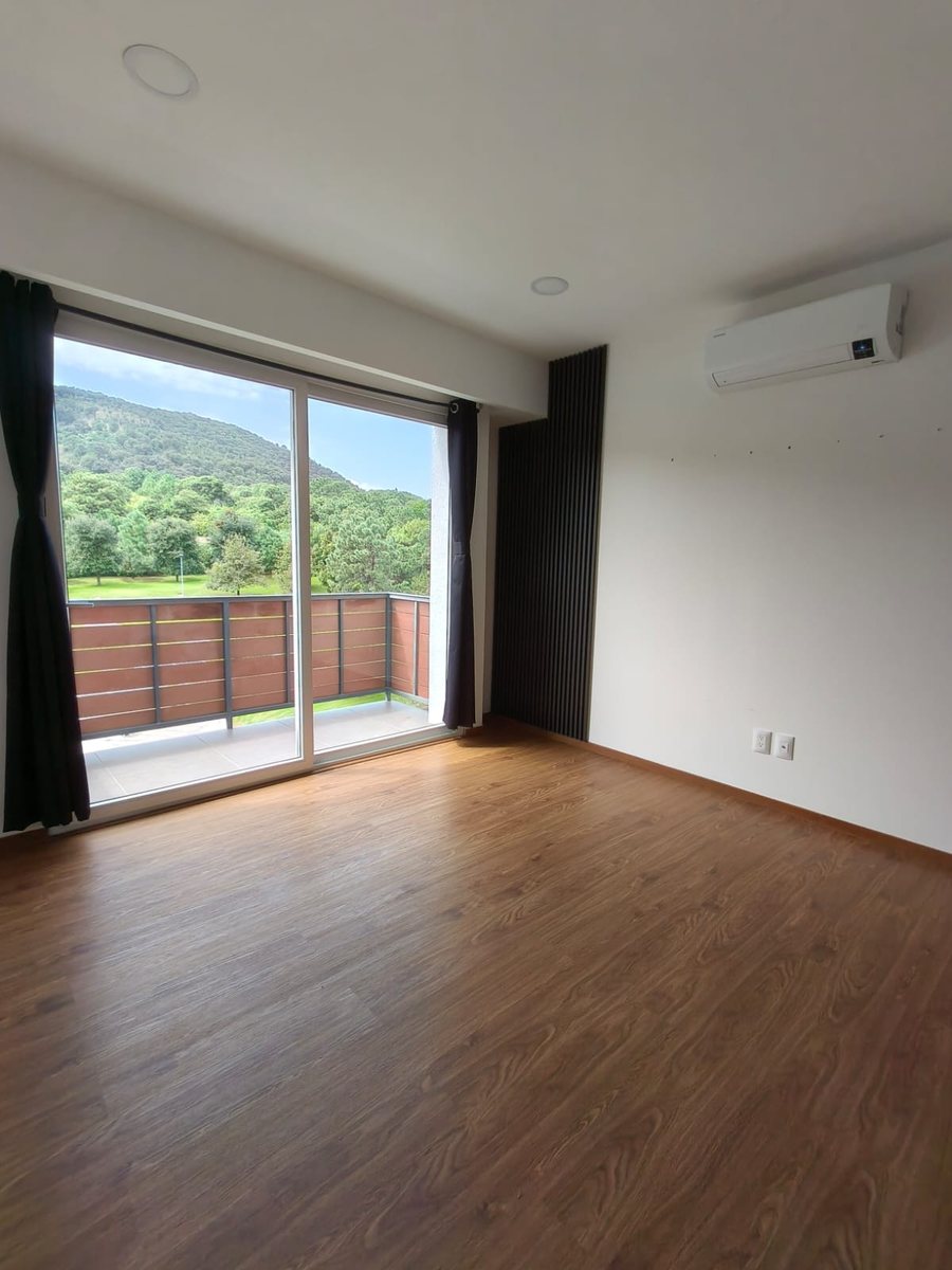 Recámara con piso de madera y salida al balcón