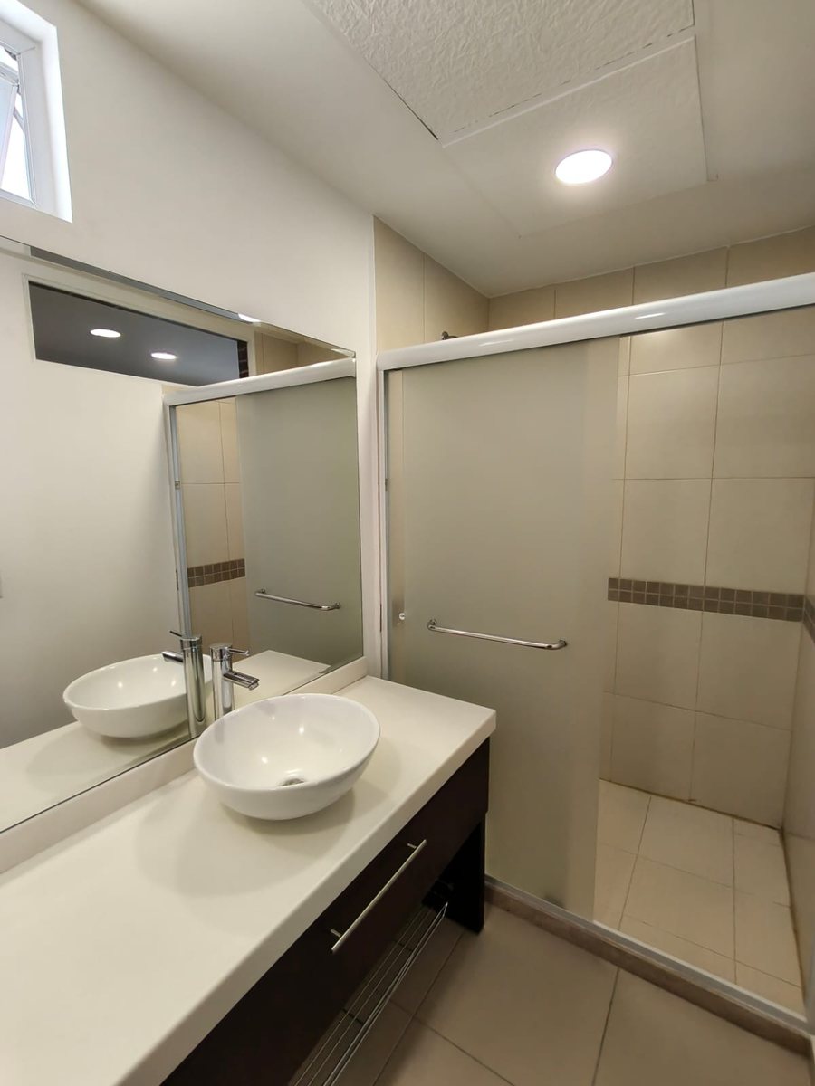 Baño con lavabo de cerámica y cancel de cristal