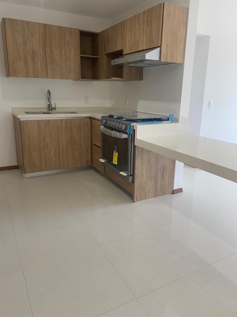 Cocina integral con alacenas de madera, estufa y barra