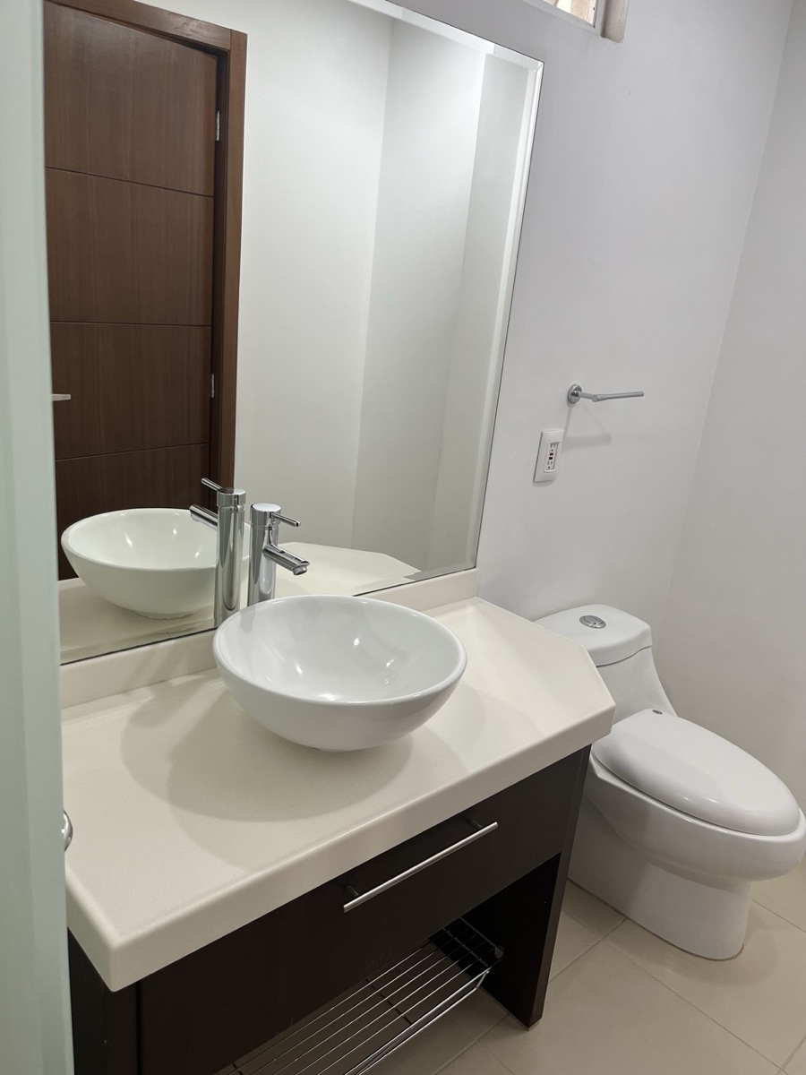 Baño con lavabo de cerámica y mueble de madera