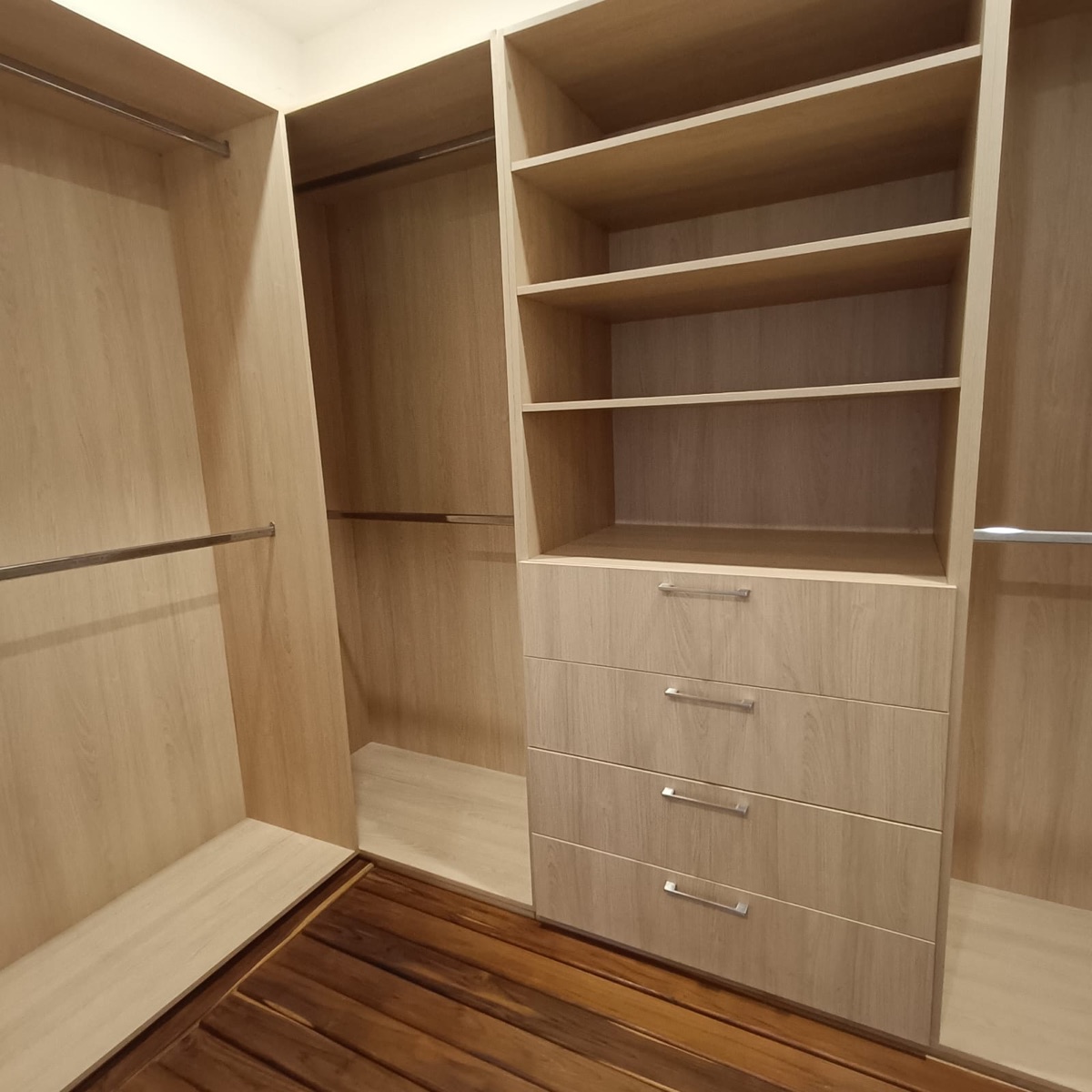 Vestidor de madera con repisas, cajones y barras para colgar