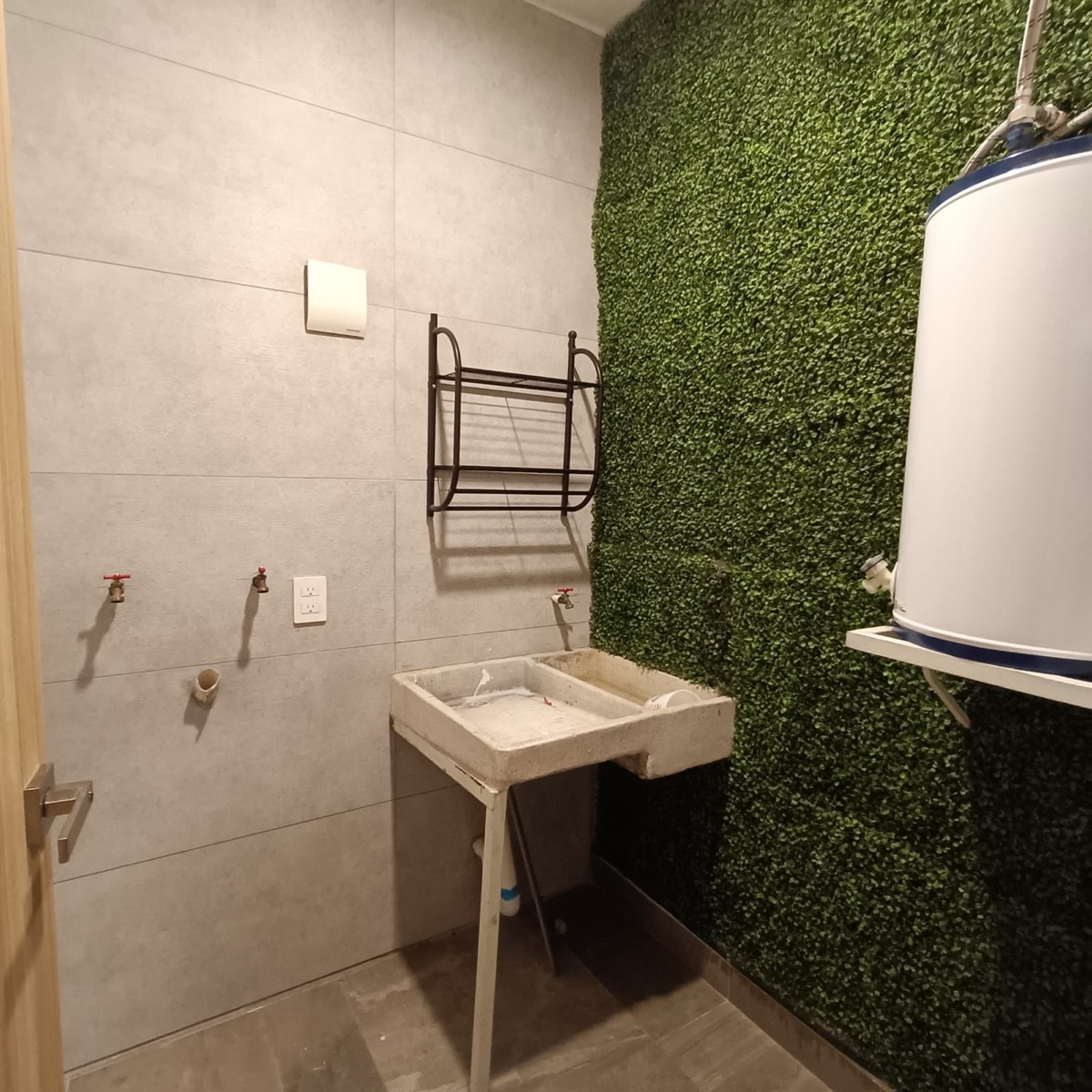Área de servicio con lavadero, calentador y muro verde