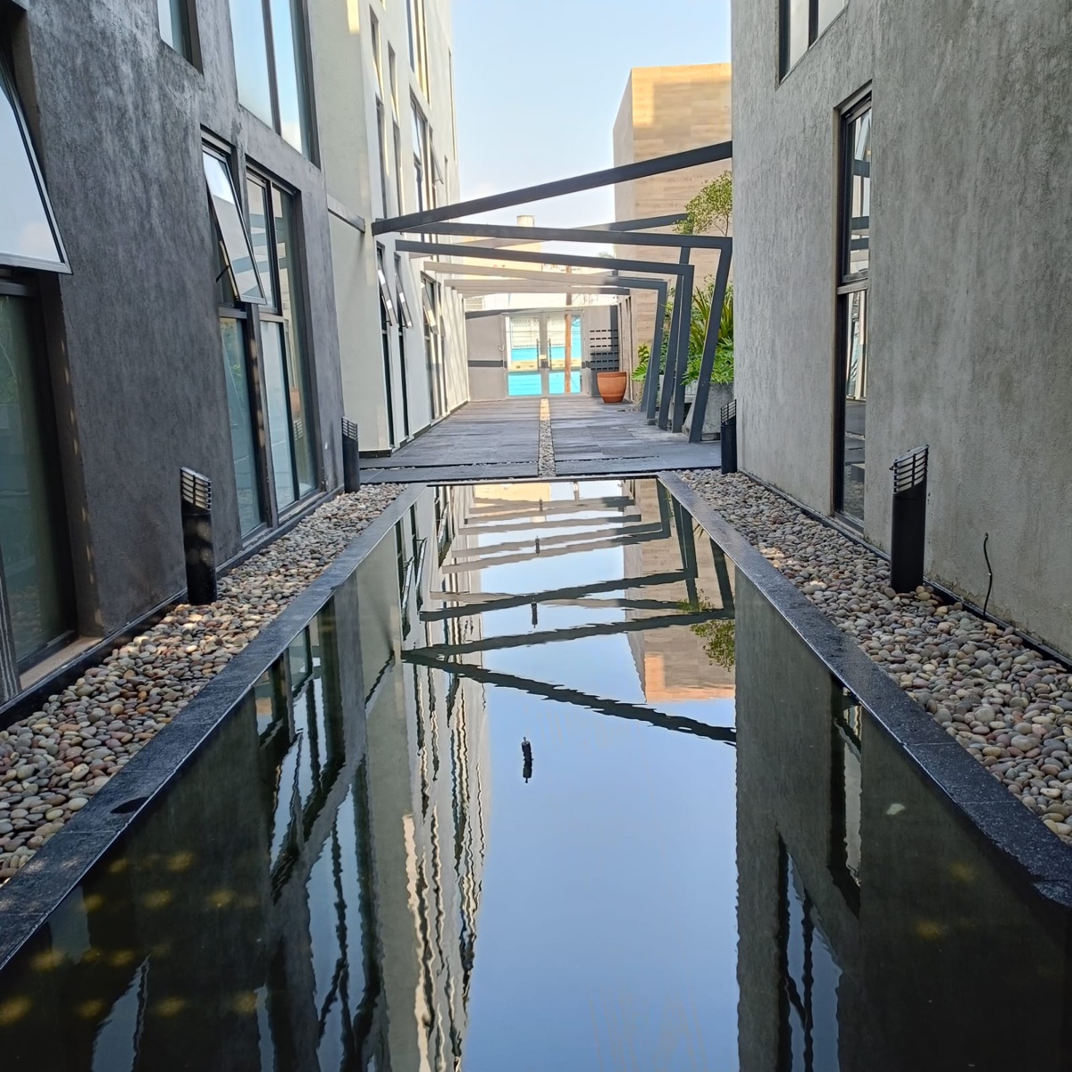 Espejo de agua con pérgola al fondo
