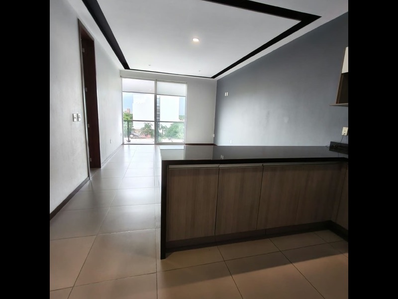 Sala y comedor con plafón de doble altura y ventanal hacia el balcón
