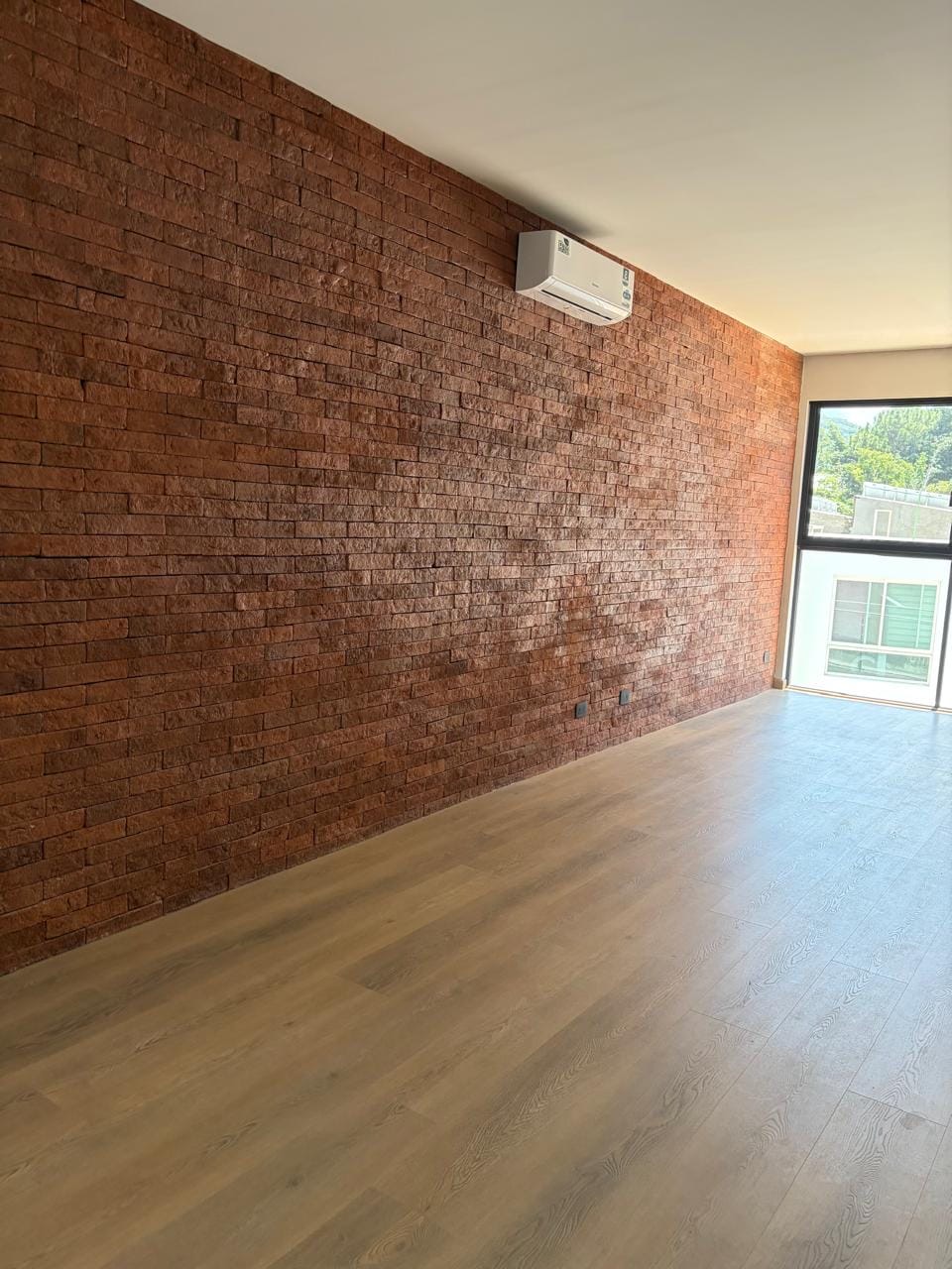 Muro de ladrillo con aire acondicionado y ventanal