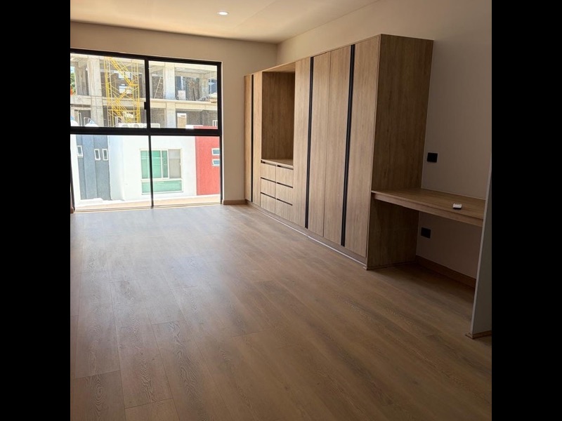 Estudio con ventanal, clóset de madera y escritorio