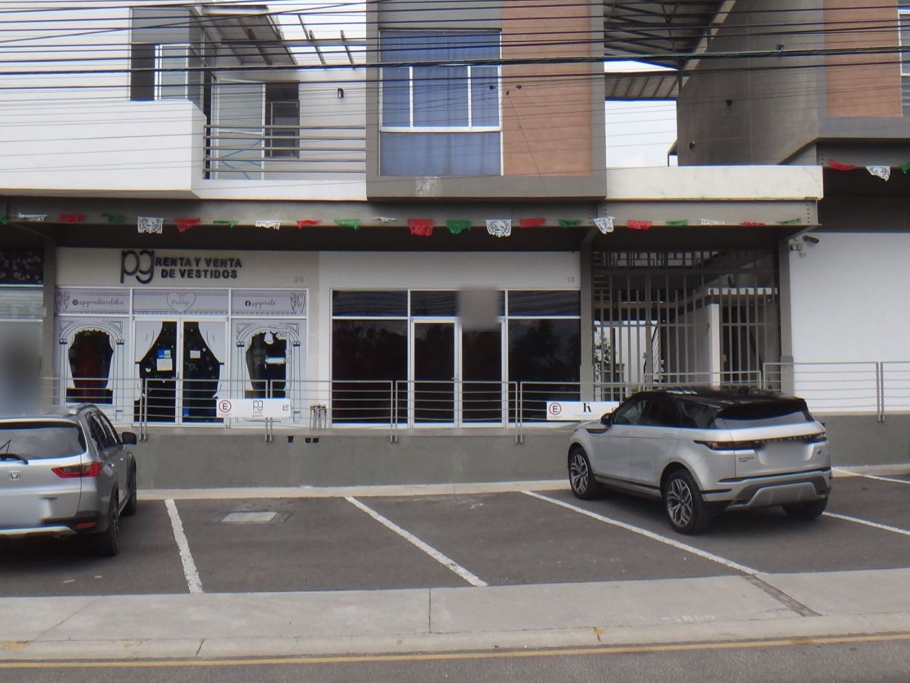 Fachada del local en la plaza, con estacionamiento al frente